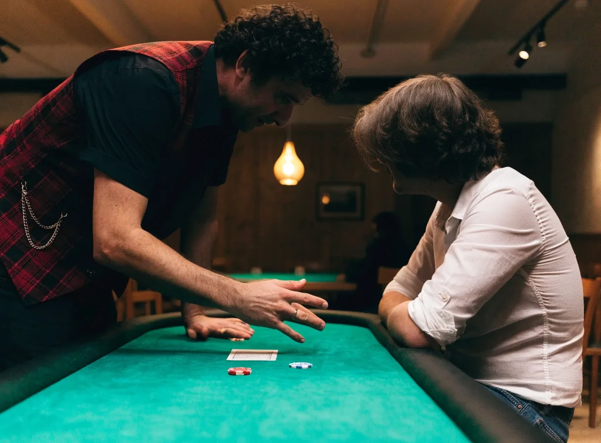 Dealer vysvětluje nováčkovi pravidla pokeru u stolu v herně