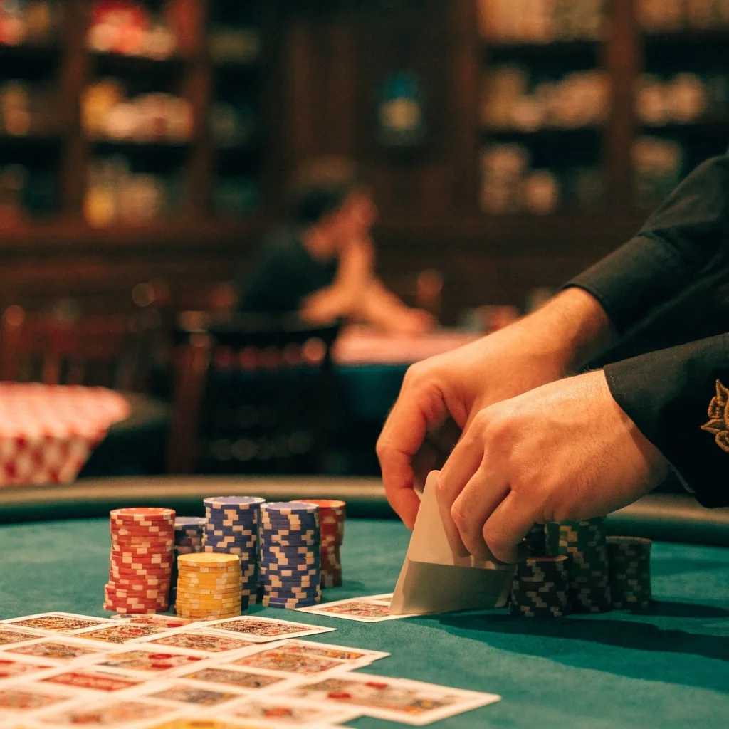Dealer upravuje balíček karet u pokerového stolu v herně Dvora Zeleného